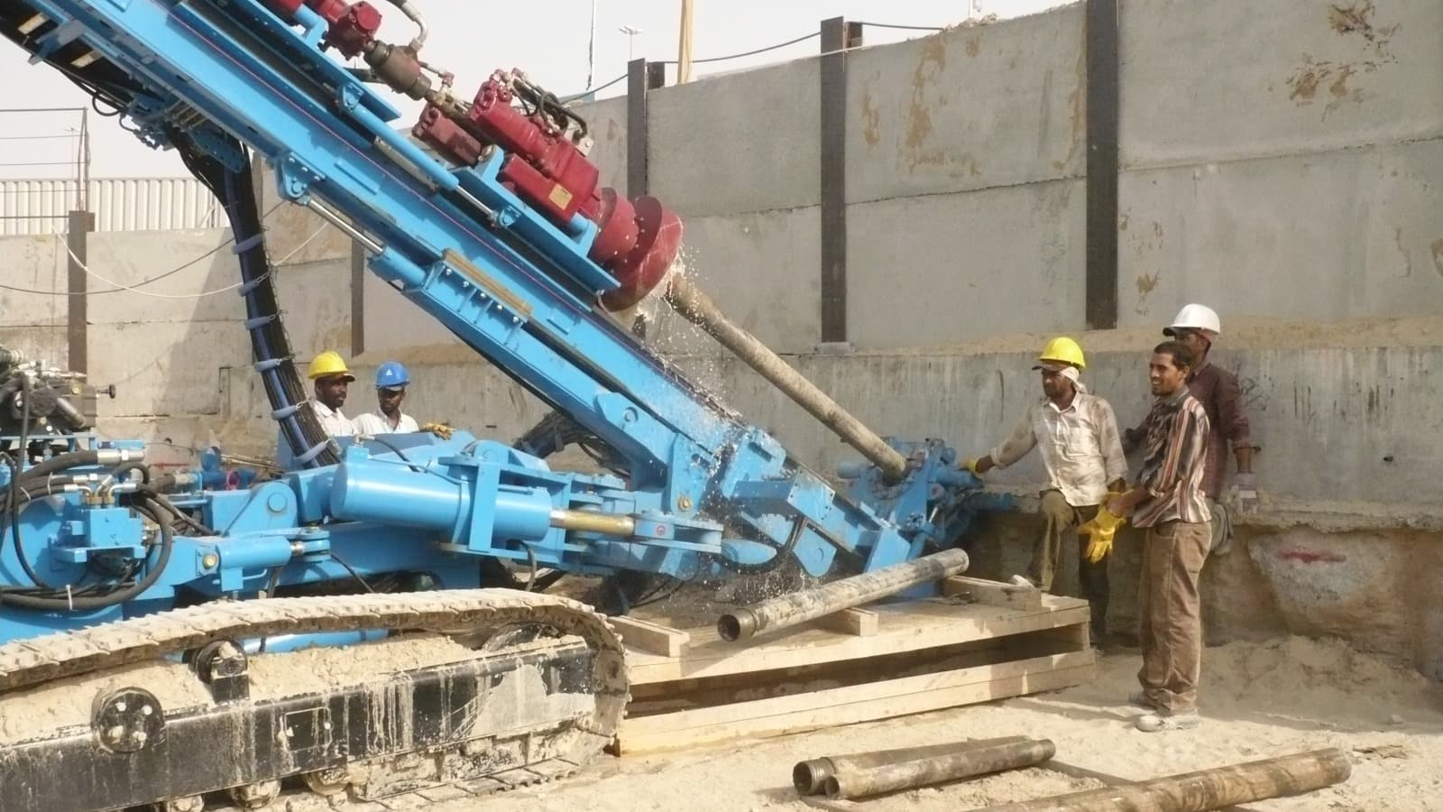 Apex anchoring rig drilling a tie-back ground anchor into a shored excavation wall on a UAE construction site