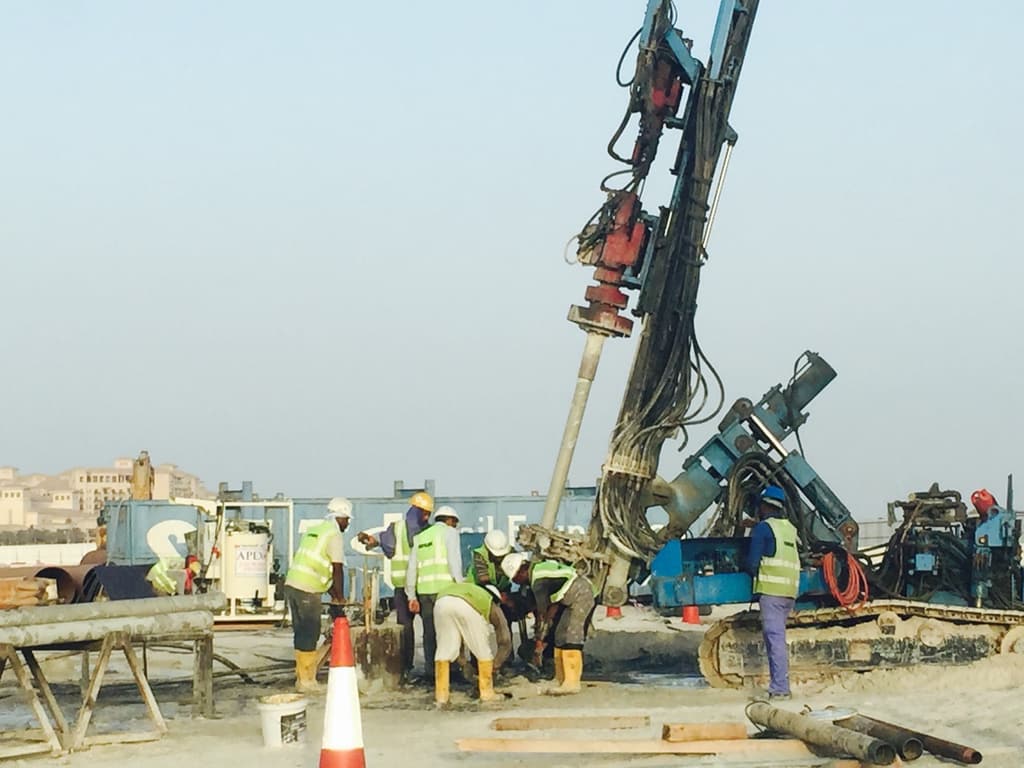 Apex drilling rig and crew installing ground anchors on a UAE construction site